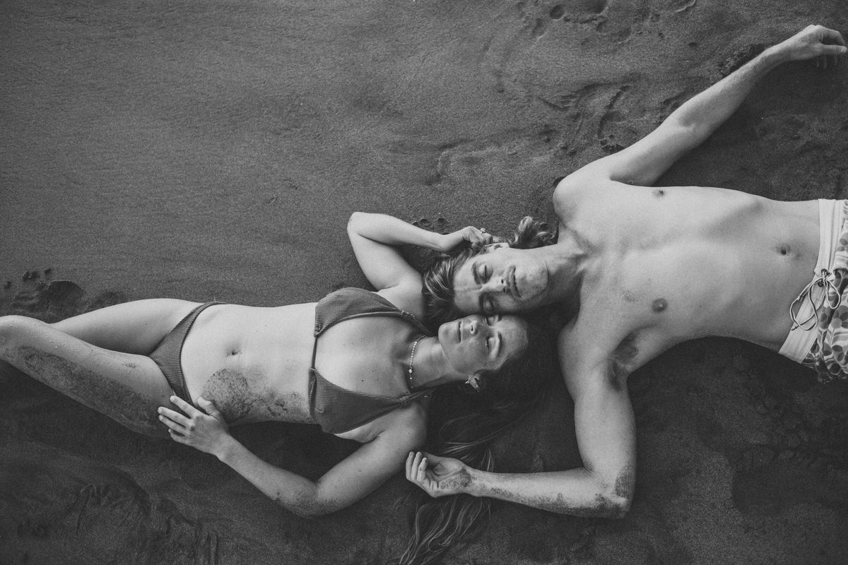 couple laying in the sand on the beach